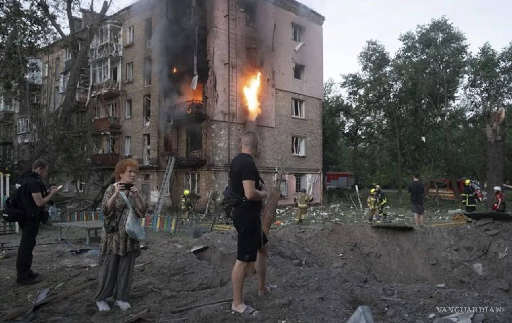 $!Los vecinos se reúnen en el lugar donde un misil ruso ha impactado en una zona residencial de Kiev, Ucrania.