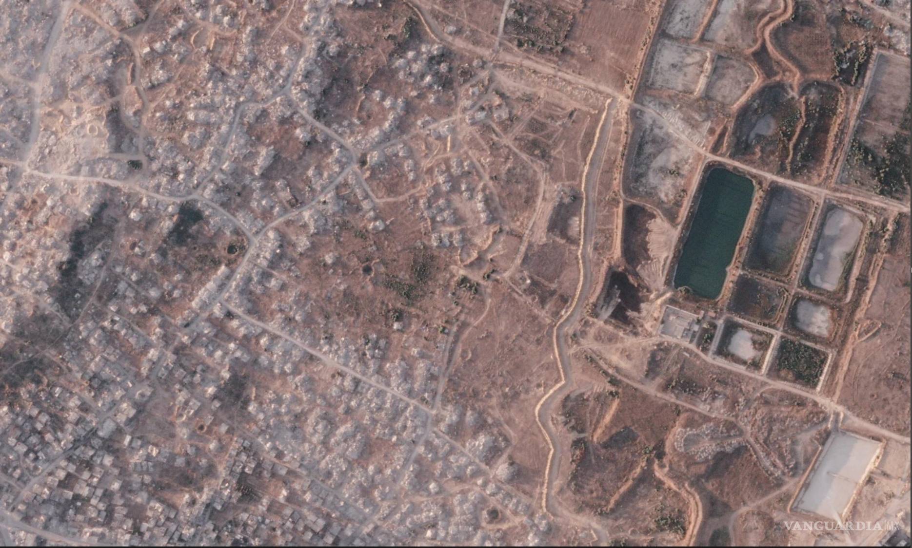 $!Una sección de una barrera de tierra construida por el ejército israelí en el norte de la Franja de Gaza. A la izquierda la ciudad demolida de Beit Lahia.
