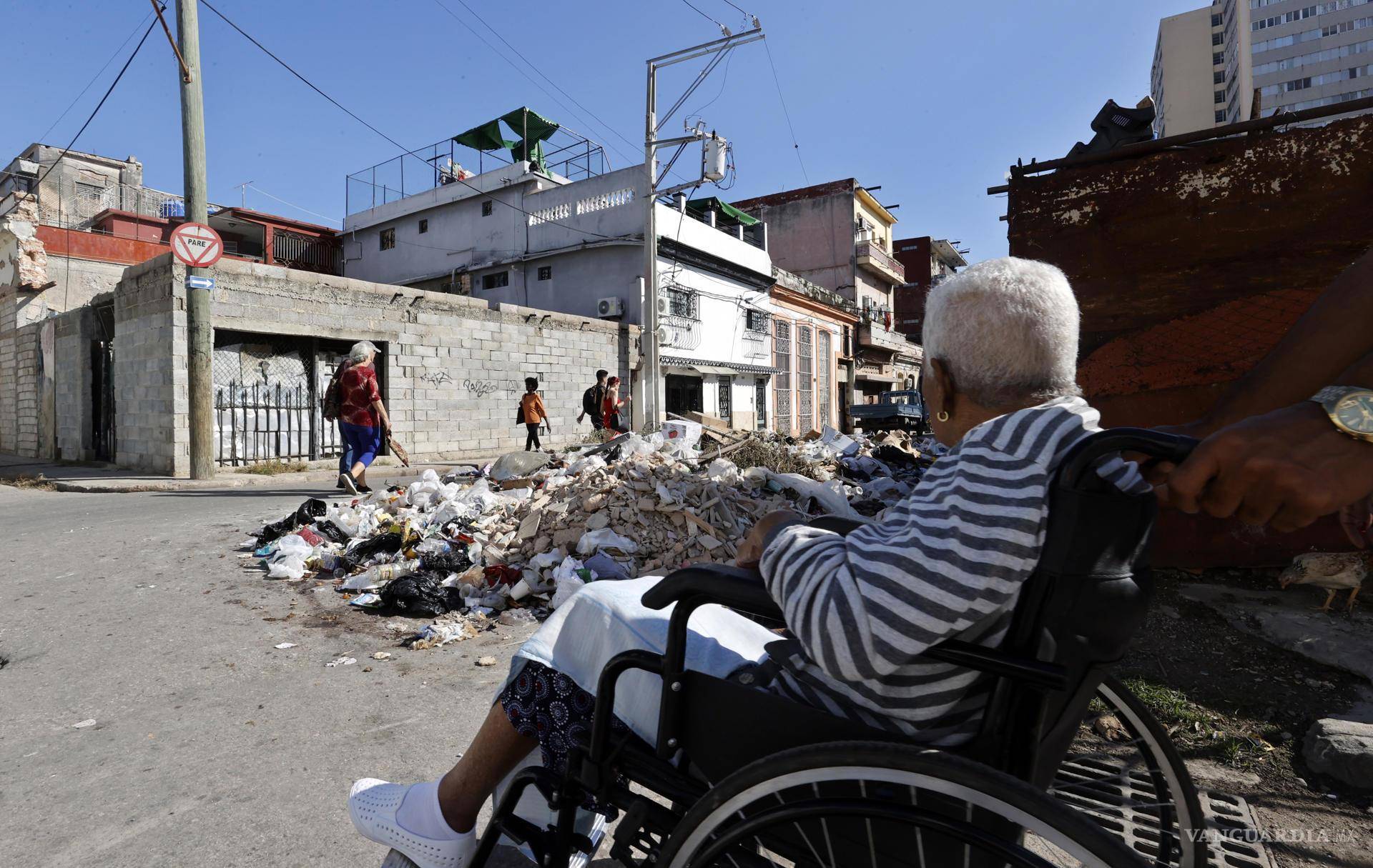 $!Un grupo de personas camina por una calle con basura, en La Habana, Cuba.
