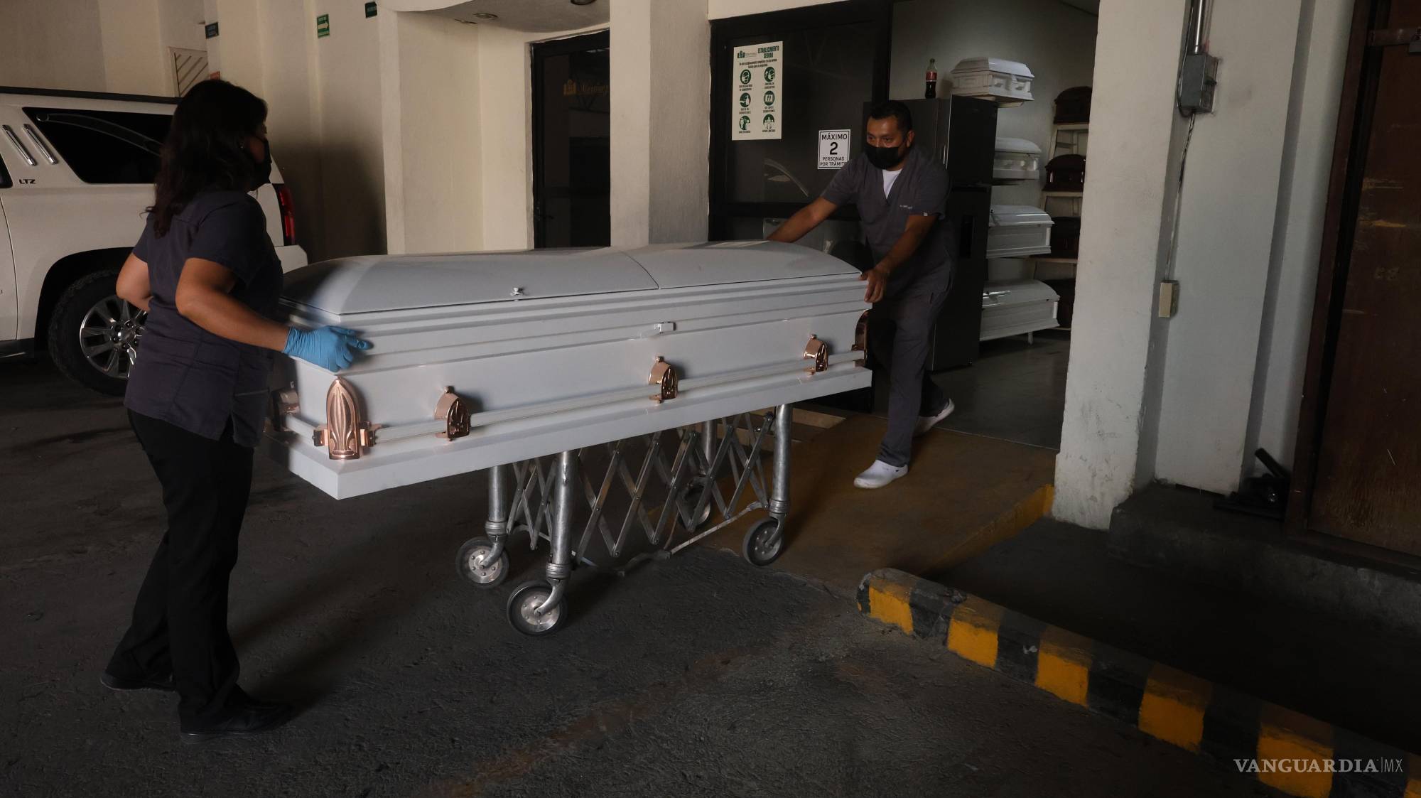 $!Los embalsamadores llevan el ataúd hasta el acceso principal de la funeraria. “Vivimos siempre con el dolor ajeno”, dice Martín, quien recuerda jornadas de hasta ocho cuerpos en un día.