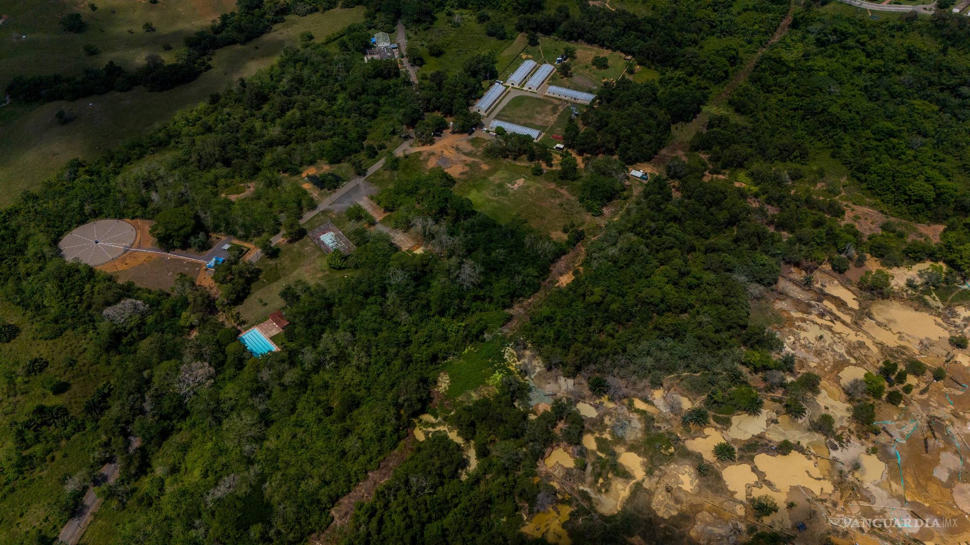 $!Los pozos mineros fangosos del lado derecho se encuentran en propiedad militar. La operación se ha expandido progresivamente hacia la piscina y los edificios anexos de la base.