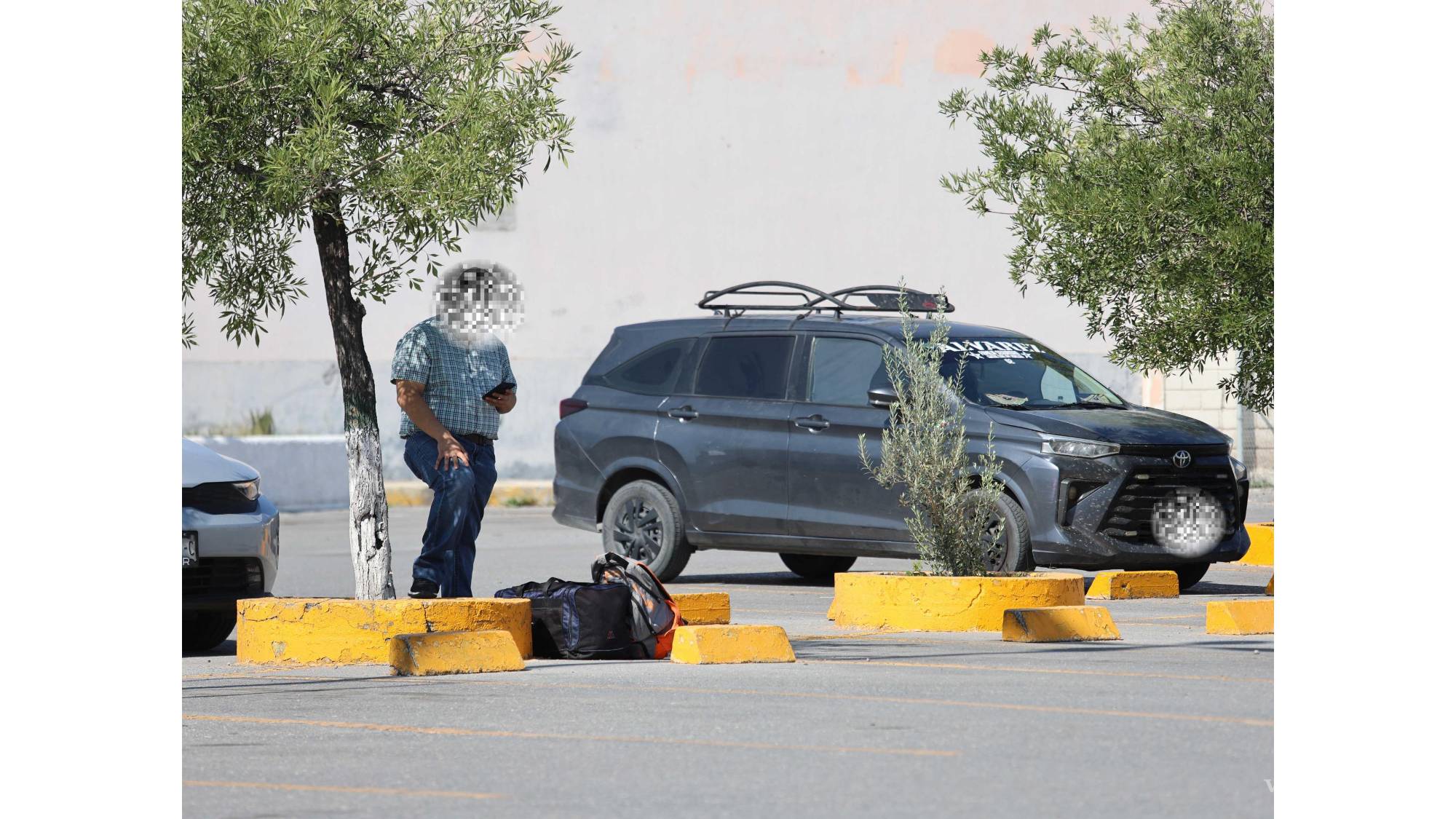 $!La espera ocurre a la sombra, junto a las maletas: antes del viaje, cada pasajero parece confirmar en silencio si está en el lugar correcto.