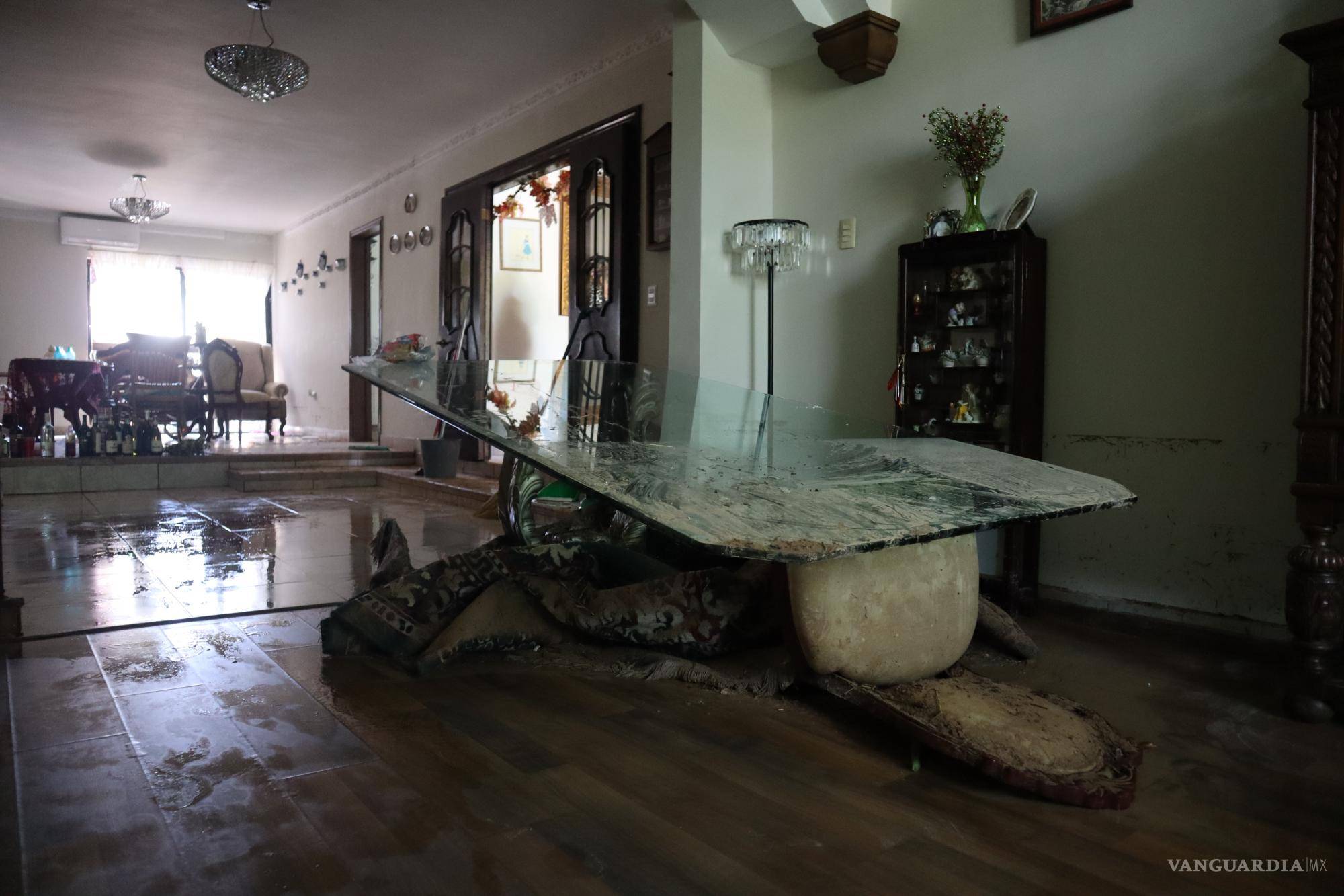 $!La barda que divide al estacionamiento del centro comercial y el fraccionamiento, cedió ante la fuerza del agua.