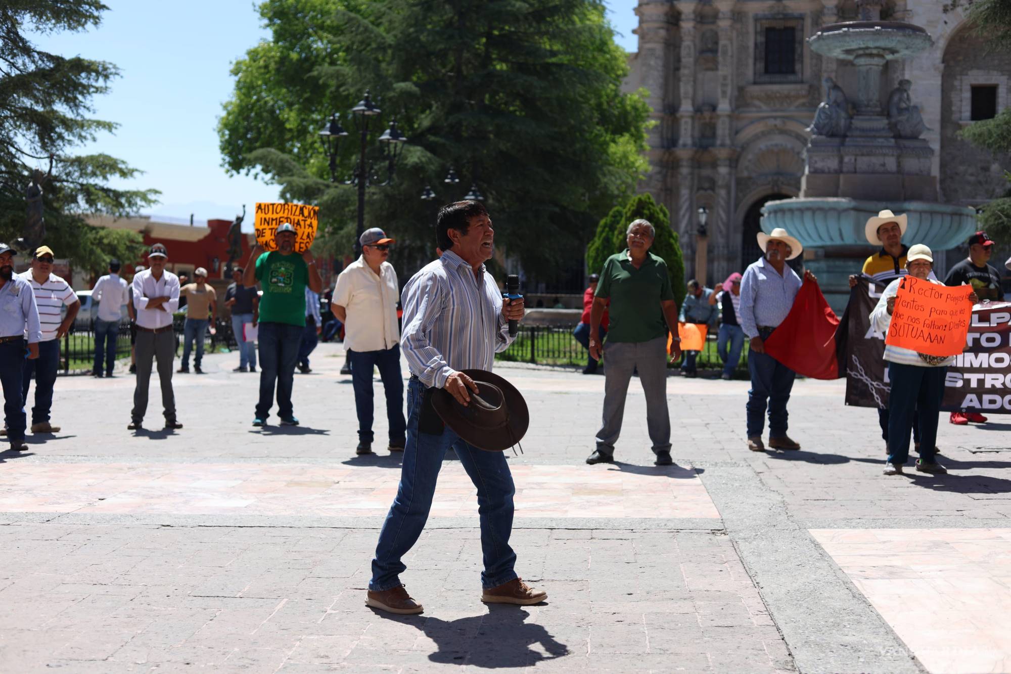$!Con sombrero en mano y micrófono firme, docentes y trabajadores de la Universidad Autónoma Agraria Antonio Narro (UAAAN) tomaron la Plaza de Armas para exigir pagos pendientes, respeto a sus derechos laborales y autonomía sindical. El reclamo resonó frente a Palacio de Gobierno como eco de una historia obrera que no se rinde.