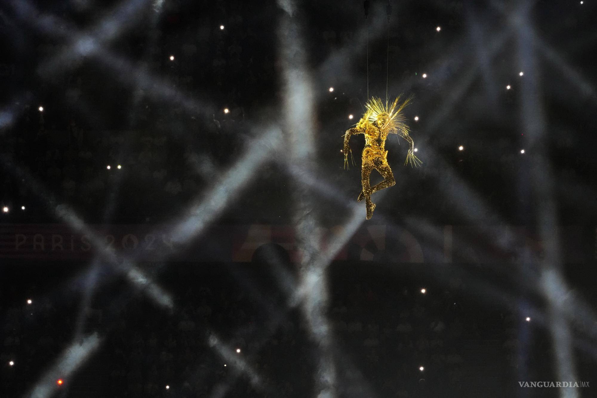 $!Figuras enmascaradas descienden del techo del estadio en una impresionante danza contemporánea, descubriendo los anillos olímpicos suspendidos sobre el centro.