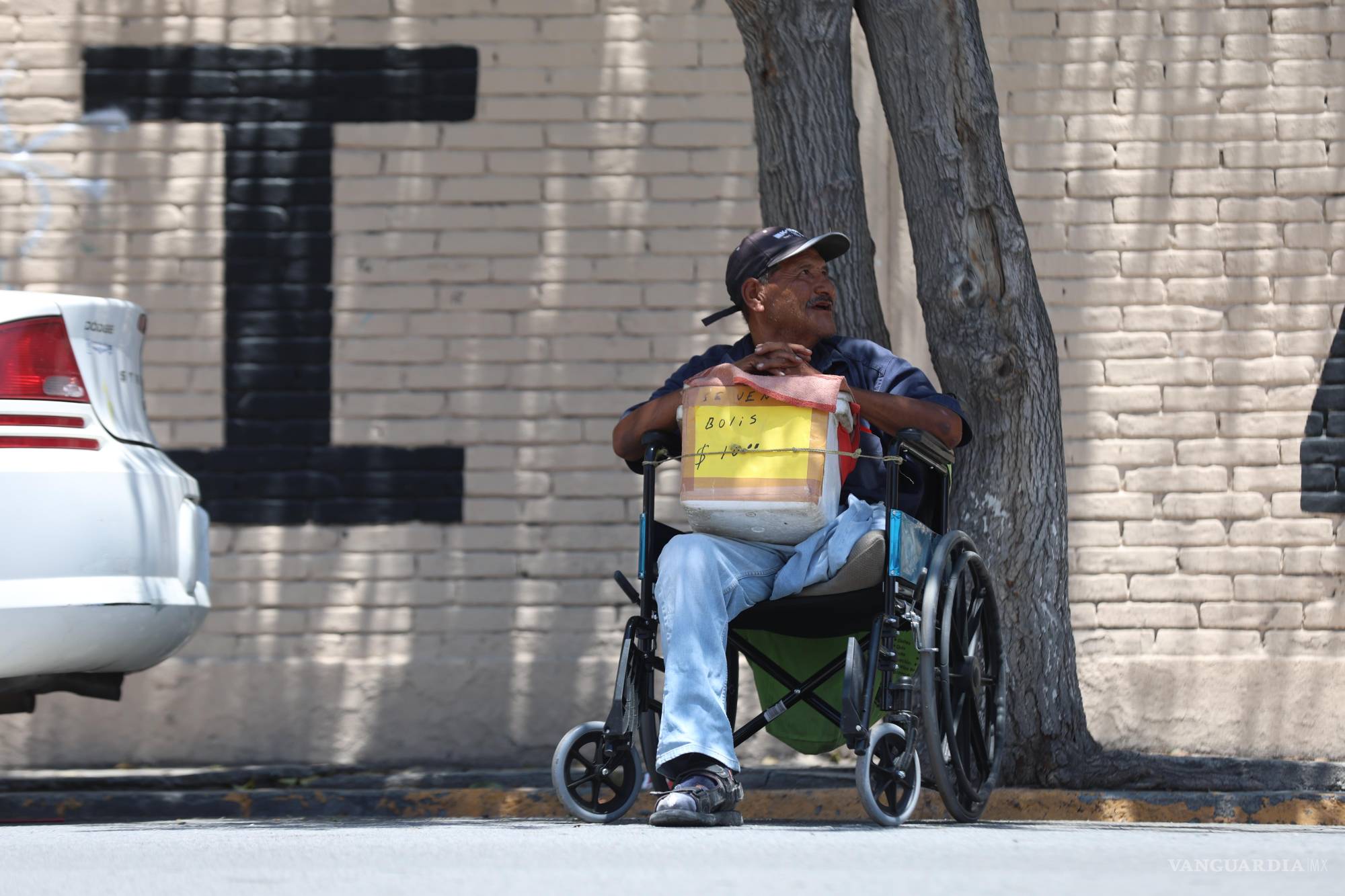 $!Don Anastasio recorre en silla de ruedas la colonia Guayulera para vender bolis, sorteando obstáculos.