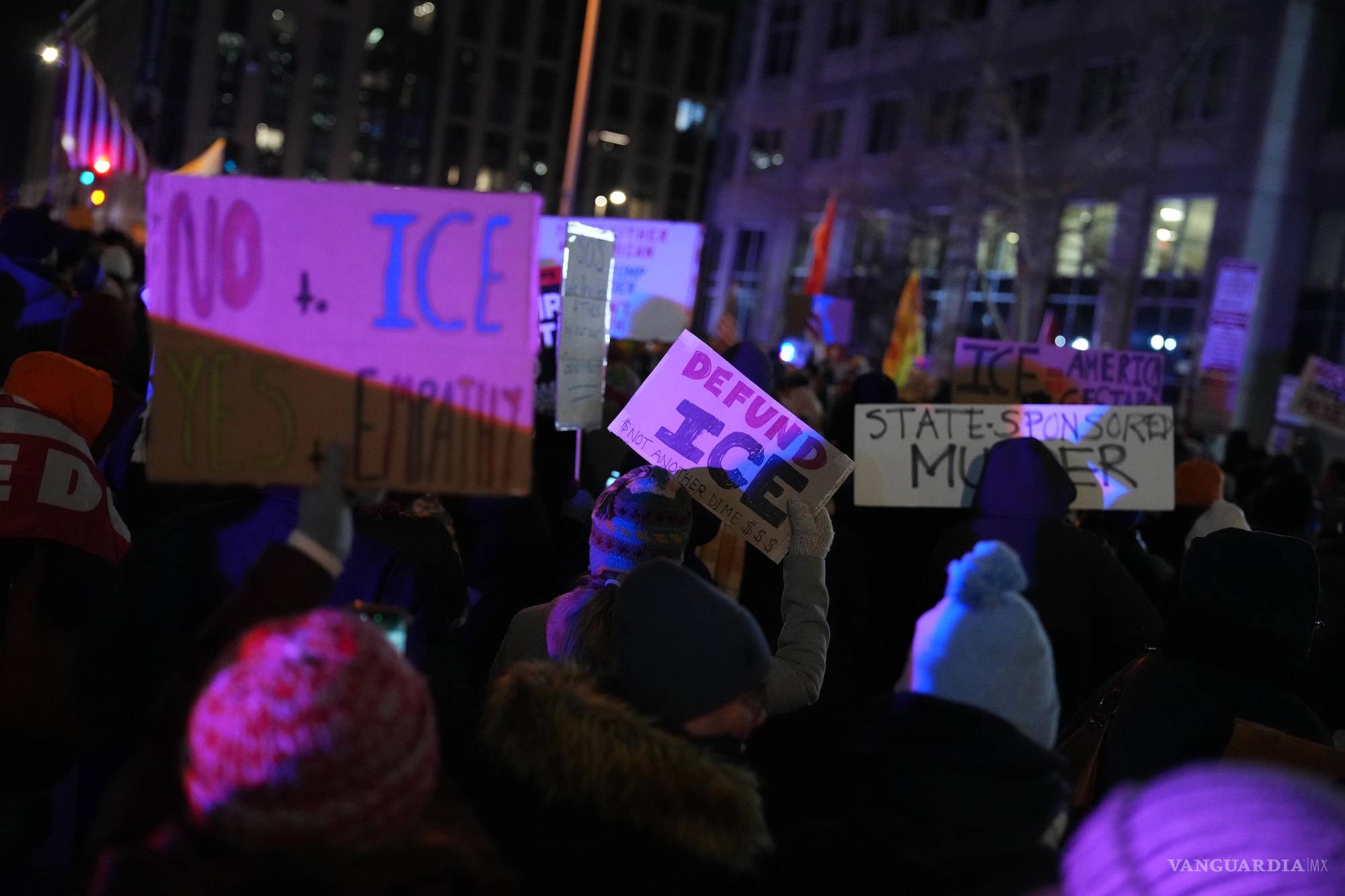 $!Pancartas iluminadas por la noche exigen el desfinanciamiento del ICE y denuncian la violencia institucional en las zonas donde se hospedan los agentes.