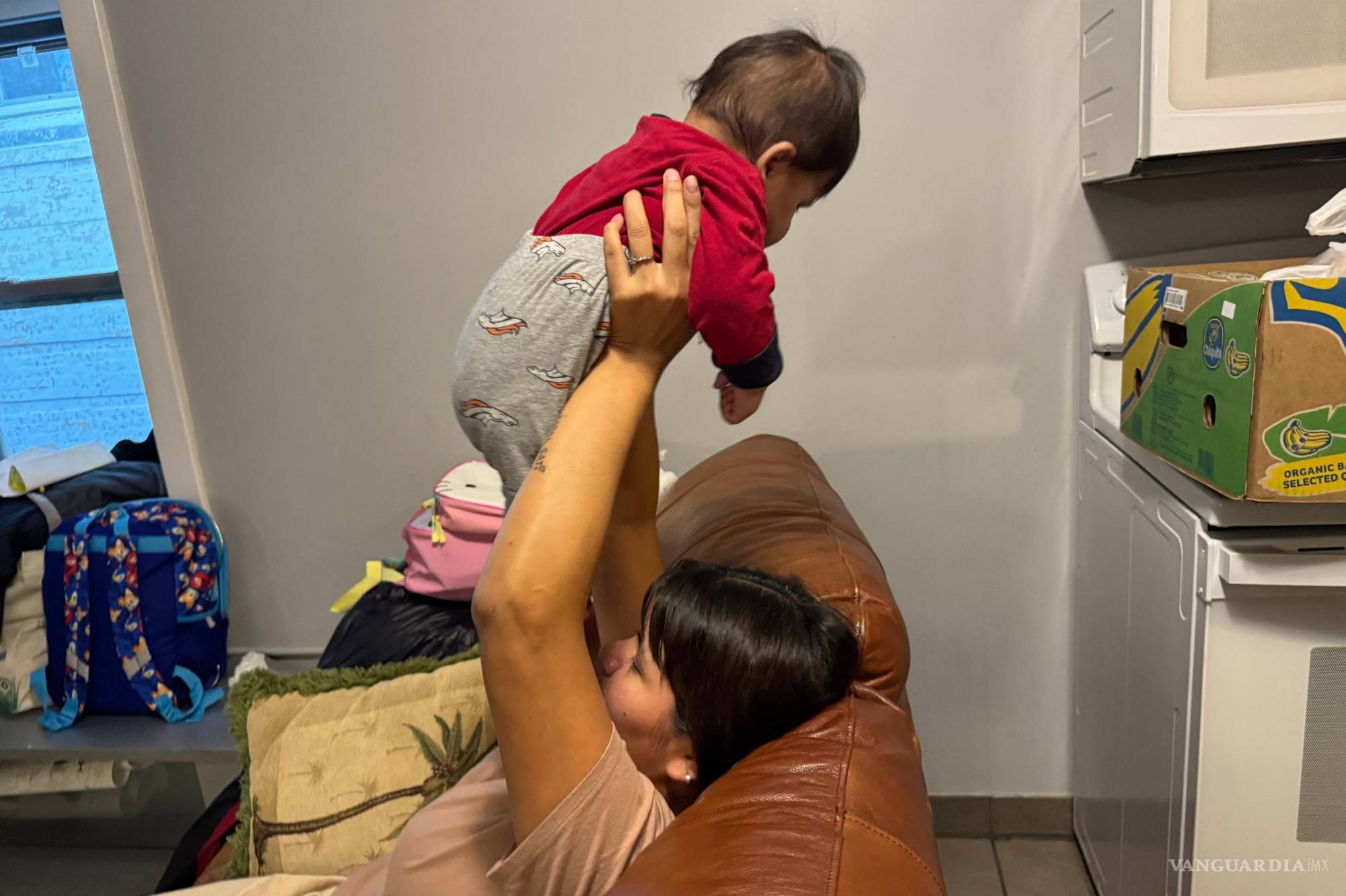 $!Una mujer sostiene a su hermano menor de 5 meses tras llegar a una casa de seguridad en Minneapolis después de que agentes detuvieran a su madre.