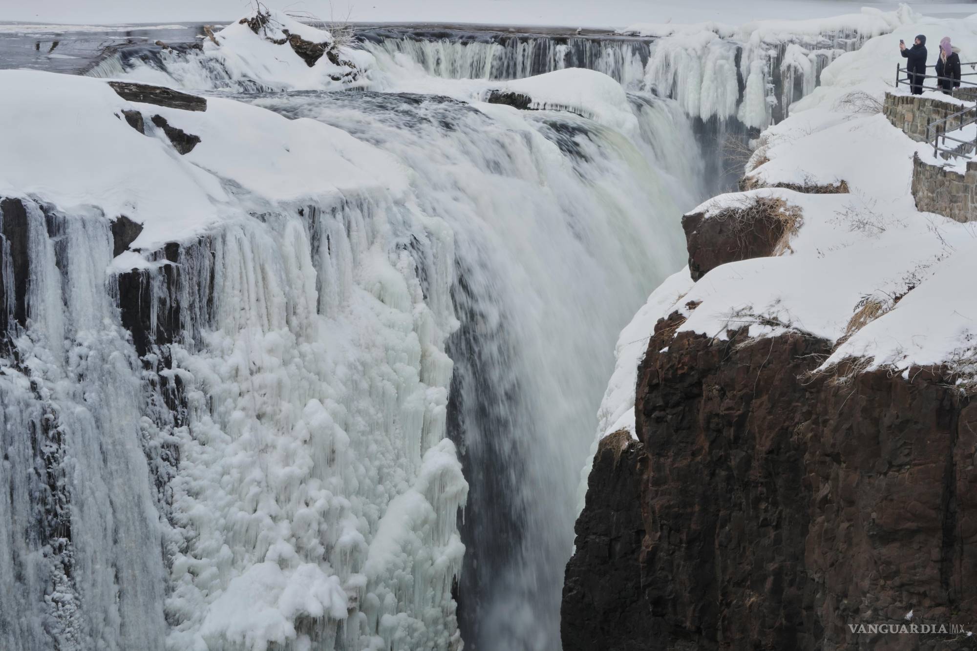 $!La gente observa las cataratas Great Falls parcialmente congeladas en Paterson, Nueva Jersey, el miércoles 28 de enero de 2026.