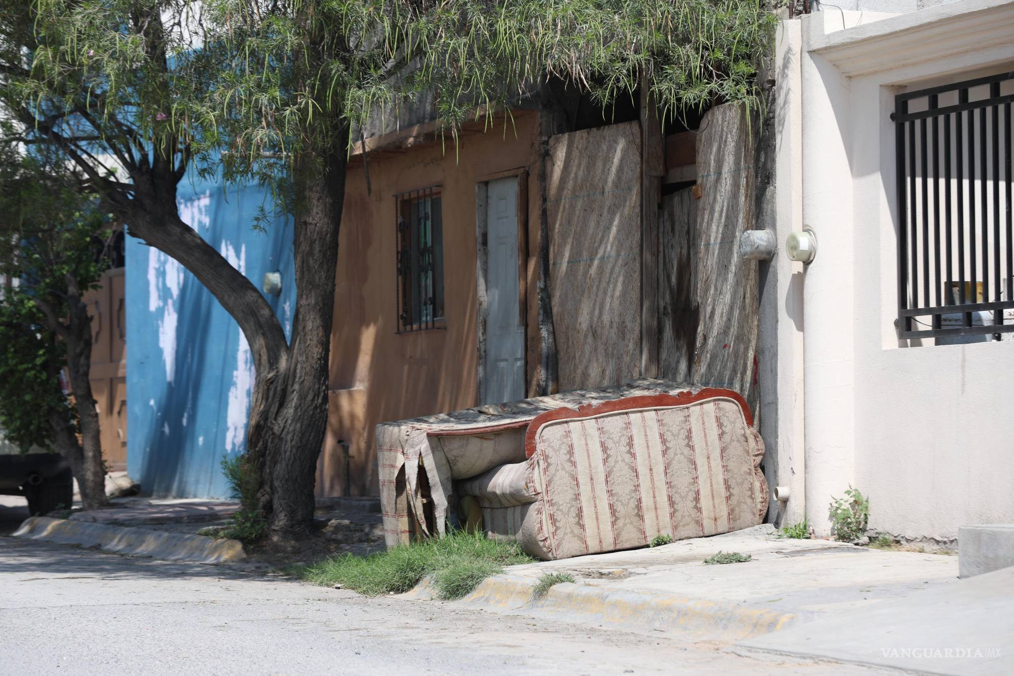 $!La acera está ahí, pero nadie puede usarla: un mueble bloquea el paso mientras una madre baja al arroyo con su bebé.