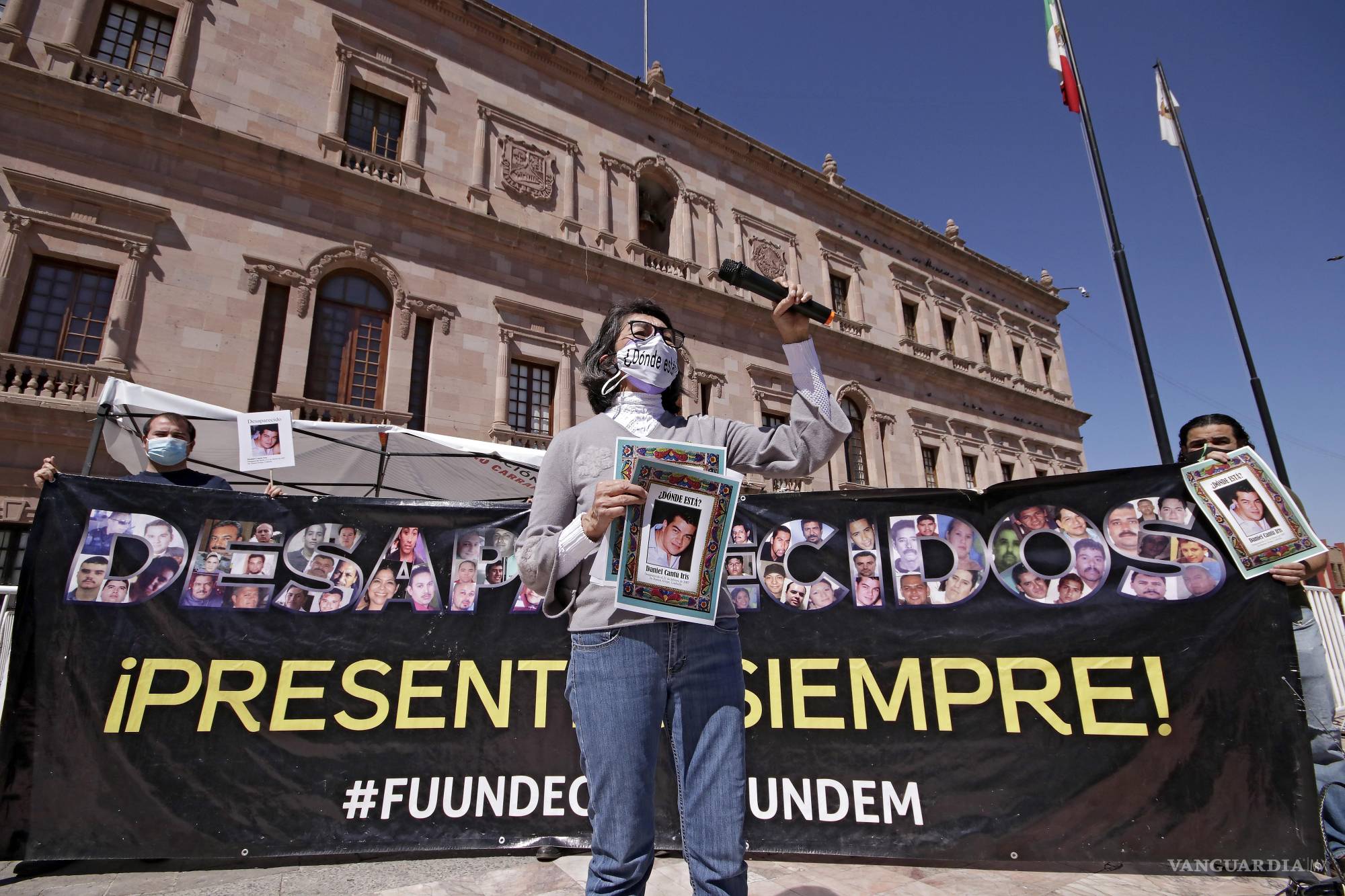 $!Diana Iris García, una de las fundadoras del colectivo Fuerzas Unidas por Nuestros Desaparecidos en Coahuila (Fuundec), sostiene el retrato de su hijo Daniel Cantú Iris, desaparecido desde hace más de 18 años. Frente al Palacio de Gobierno de Saltillo, su voz sigue preguntando lo mismo: “¿Dónde están?”. La manta, tejida con rostros y ausencias, exige lo que aún no llega: justicia.