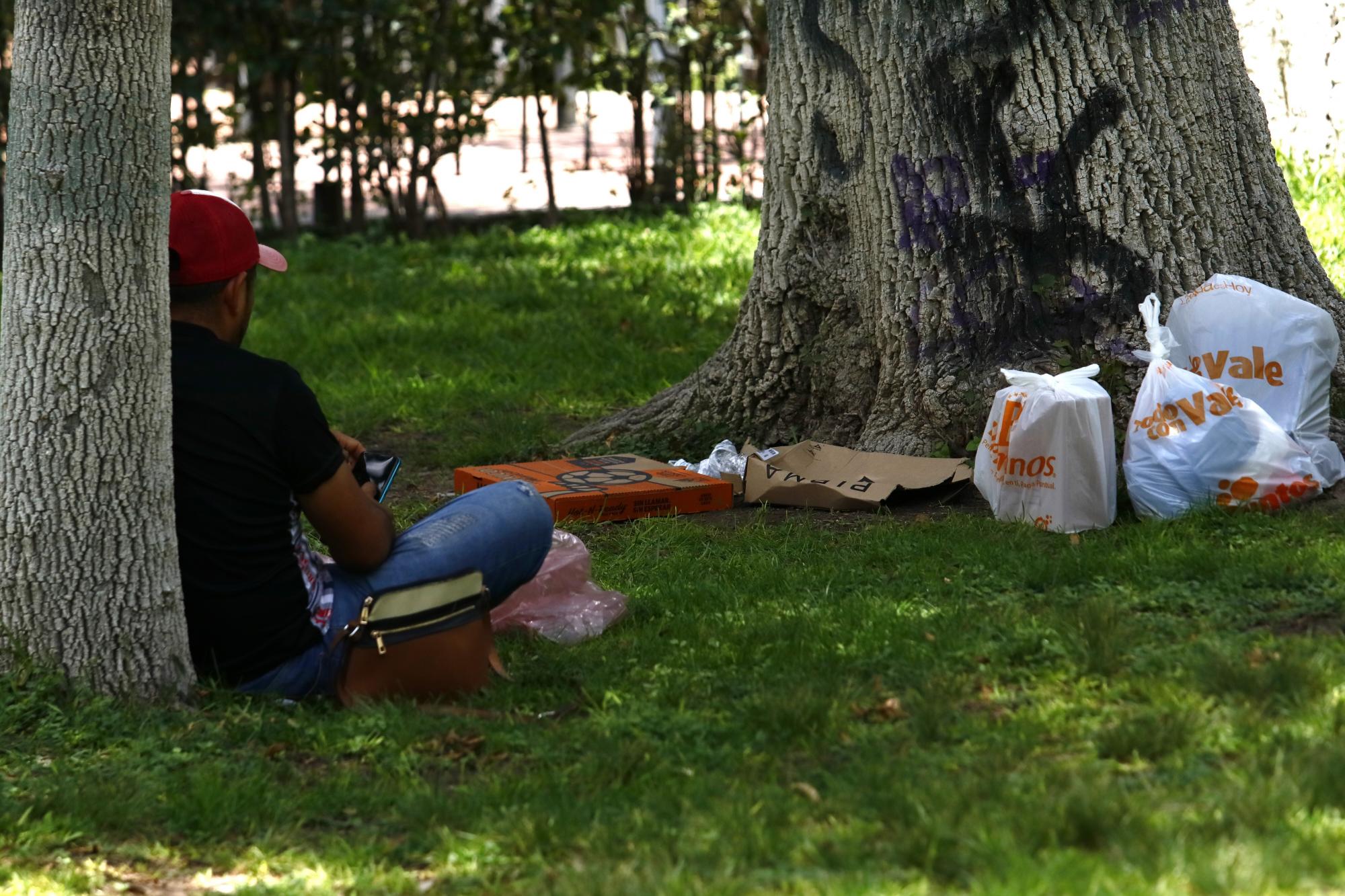 $!Visitantes prefieren comer pizza mientras pasean por la Alameda, aunque esto contribuye a la acumulación de basura.