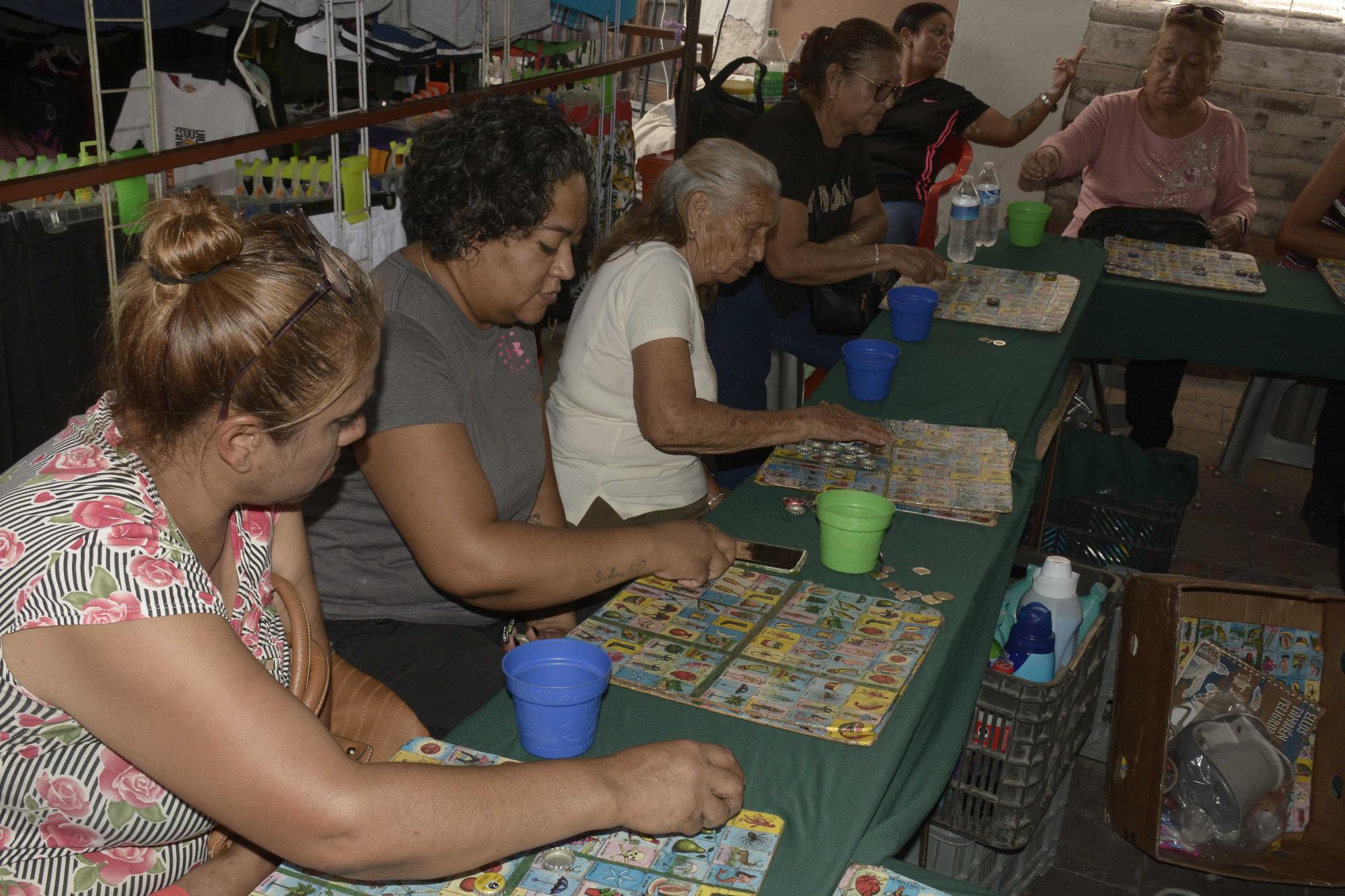 $!Mujeres juegan lotería a las afueras del templo.
