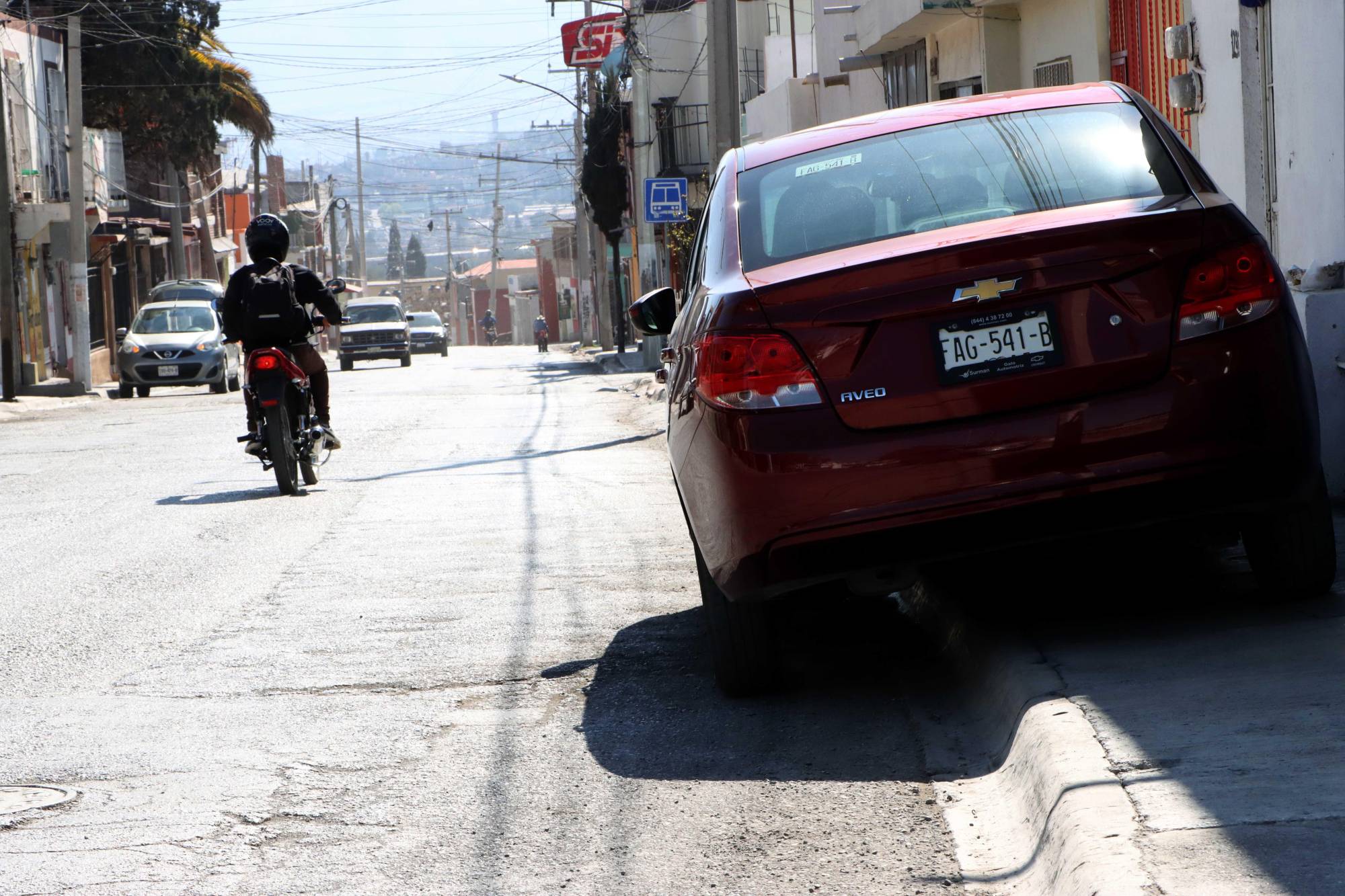 $!Lo angosto de las calles “obliga” a automovilistas a invadir el área peatonal.