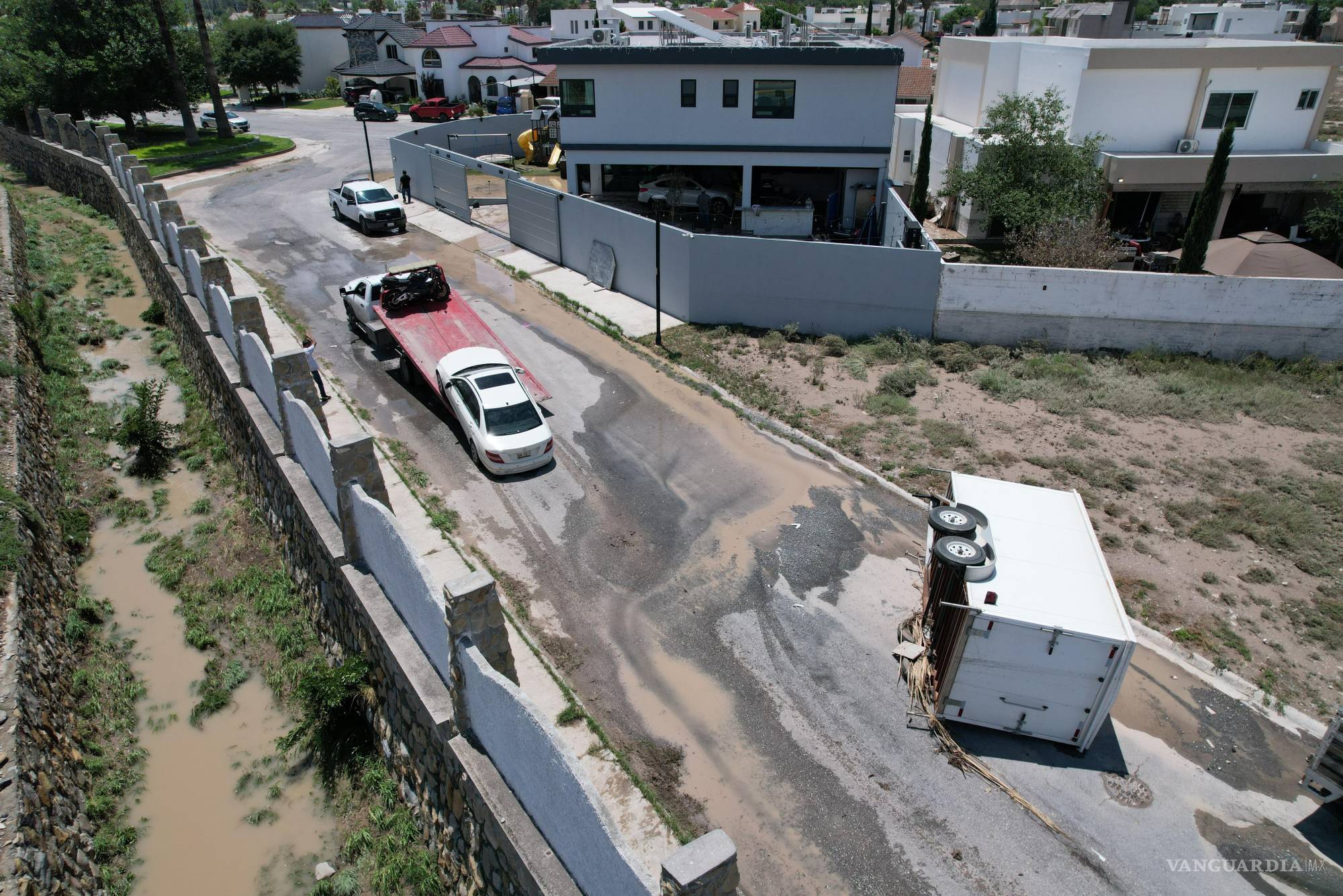 $!En el fraccionamiento Country Club, un auto fue arrastrado por la corriente y un poste derribado provocó un incendio en una vivienda deshabitada.