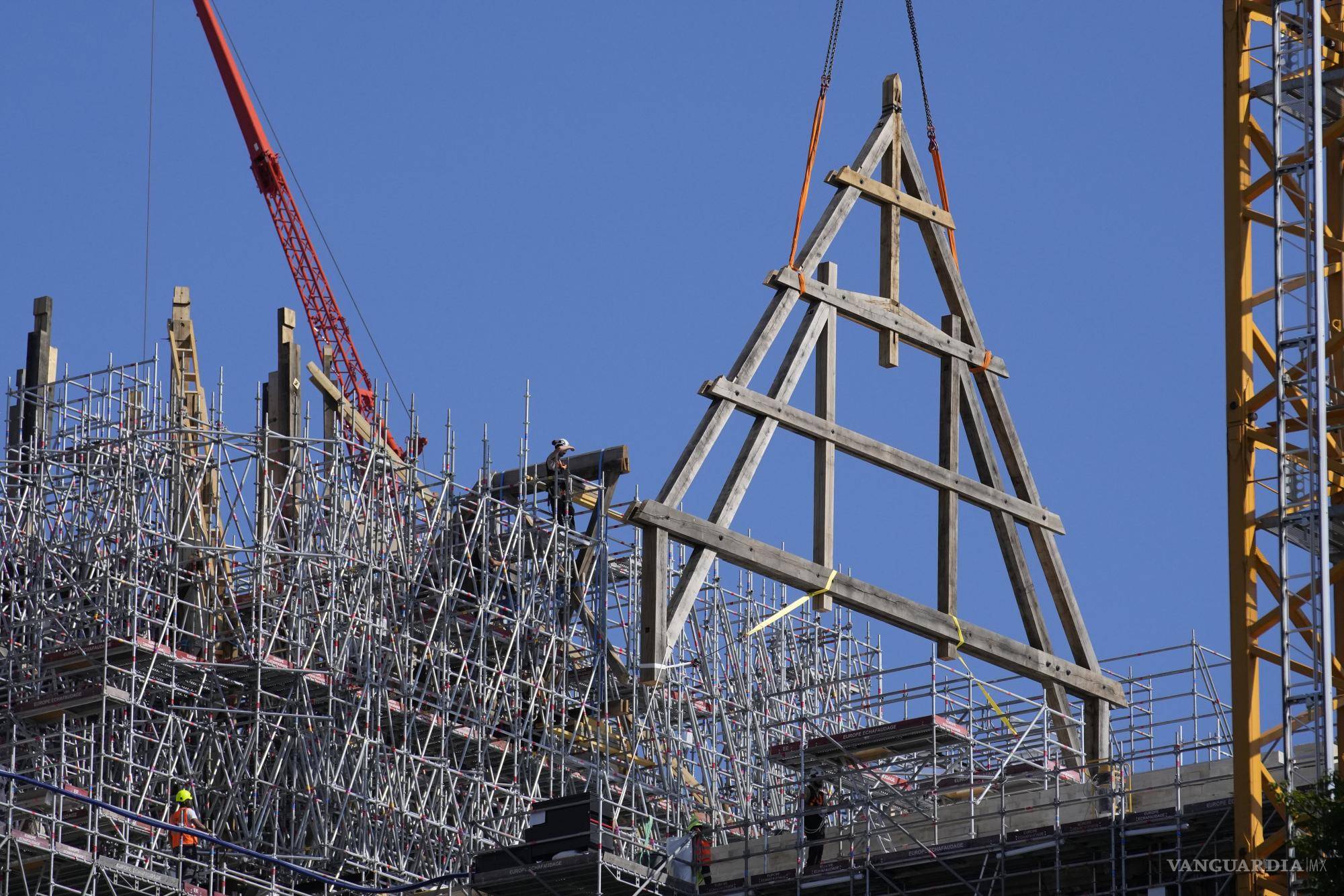 $!Una grúa levanta un enorme marco de roble en la catedral de Notre Dame de París, el martes 11 de julio de 2023 en París.