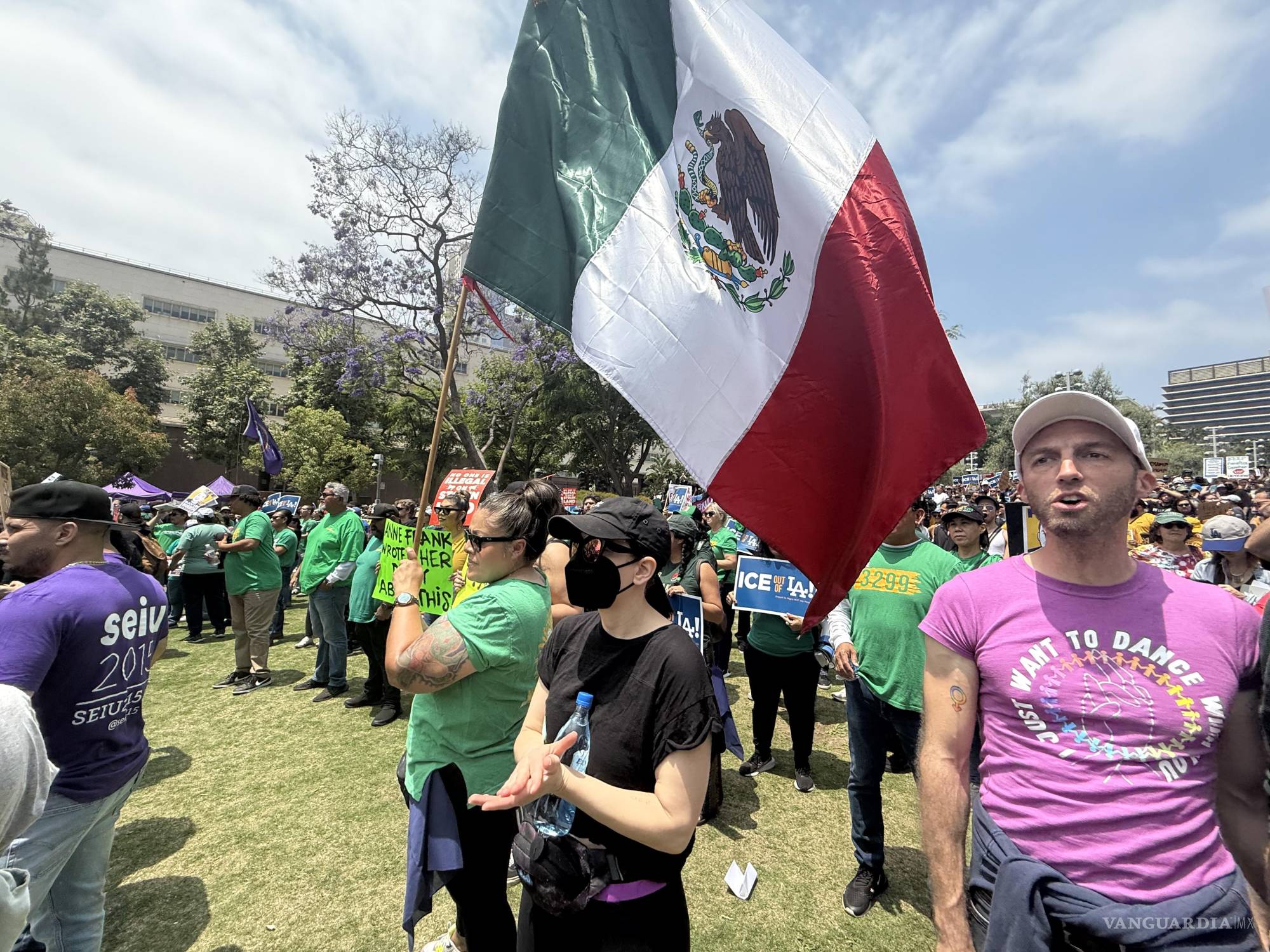 $!Una persona sostiene una bandera de México durante una protesta contra las redadas migratorias este lunes, en el centro de Los Ángeles