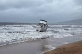 En esta foto proporcionada por el condado Maui, un barco está encallado en una playa frente a Kihei, Hawai, durante una fuerte lluvia.