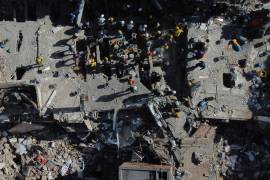 Voluntarios y rescatistas utilizan cubos para retirar los escombros de un edificio derrumbado un día después de un sismo que remeció Cali, Colombia, el 11 de agosto de 2026.