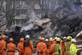 Una cuadrilla de bomberos observa los restos de un edificio en el lugar donde se registró una explosión que destruyó varios apartamentos, en La Haya, Holanda. FOTO: AP.