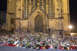 Velas, flores y guirnaldas frente a la entrada de la iglesia de San Juan a primera hora del domingo 22 de diciembre de 2024, en Magdeburgo, Alemania, después de que un coche arrollara a una multitud en un mercado navideño el viernes 20 de diciembre.