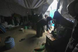 Manal Lubbad, de 49 años, madre de ocho hijos y desplazada desde Ciudad de Gaza, intenta limpiar su carpa inundada, tras fuertes lluvias durante la noche en el campamento para refugiados en Deir al Balah, en el centro de la Franja de Gaza.