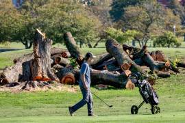 Un golfista camina cerca troncos cortados de árboles en el East Potomac Golf Links, en Washington.