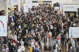 Pasajeros pasa junto a un panel de salidas después de que un ciberataque causara retrasos en el Aeropuerto Internacional de Bruselas en Zaventem, Bélgica.