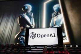 El logo de OpenAI en la pantalla de un teléfono con una imagen generada por el modelo Dall-E de texto a imagen de ChatGPT en la pantalla de una computadora en Boston.