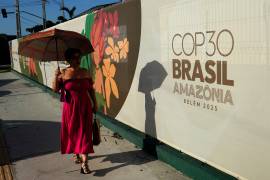 Una mujer pasa junto a un cartel de la Cumbre Climática de la ONU COP30, en Belém, estado de Pará, Brasil