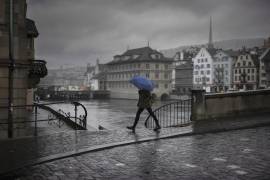 Una mujer cruza Muensterbridge sobre el río Limmat, en un día otoñal en Zurich, Suiza, el 21 de noviembre de 2023.