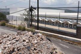 La Megafarmacia luce desolada, con una de sus dos entradas, semibloqueada por cascajo de un socavón que se formó desde enero de 2026, y no ha sido reparado.