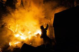 Un bombero trabaja para salvar una casa del Incendio Caldor en Meyers, California, el lunes 30 de agosto de 2021.