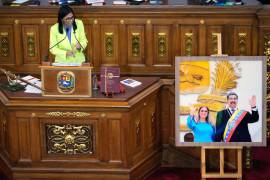 La presidenta encargada de Venezuela, Delcy Rodríguez, habla ante los legisladores junto a una foto del expresidente Nicolás Maduro y su esposa Cilia Flores, en la Asamblea Nacional en Caracas, Venezuela.