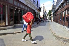 Una persona cargando una maleta por una calle, en La Habana, Cuba. El breve alivio que supuso en Cuba el crudo del petrolero ruso que evadió el bloqueo de EU está llegando a su fin.