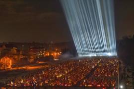 Los reflectores iluminan las tumbas de los soldados caídos mientras la gente encendía velas en vísperas del cuarto aniversario de la invasión rusa a gran escala en Lviv, Ucrania.