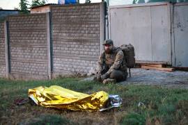 Un paramédico mira hacia el cadáver de una mujer muerta en un ataque ruso a un vecindario residencial en Zaporiyia, Ucrania, el 26 de septiembre de 2026.