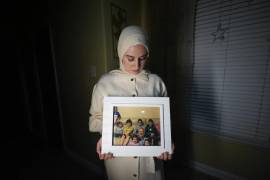 Maryam Kamalmaz muestra una fotografía de su padre con algunos de sus 14 nietos, en Grand Prairie, Texas.