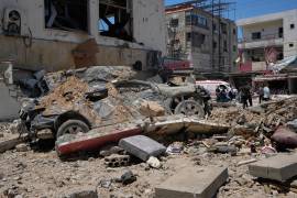 Un auto queda cubierto de escombros tras un ataque aéreo israelí en la ciudad portuaria de Tiro, en el sur de Líbano.