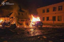 Un camión de bomberos y autobuses arden tras un ataque ruso contra una zona donde los bomberos extinguían un incendio en un centro de secundaria luego de un ataque previo, en Bohodukhiv, Ucrania.