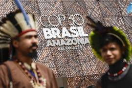 Fotografía del 11 de noviembre de 2025 de un grupo de indígenas de la tribu Pataxó, del estado de Bahía frente a un letrero que promociona la COP 30.