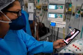 Una enfermera sostiene un teléfono durante una videollamada entre un paciente con covid-19 y sus familiares. Todos los dispositivos pueden ser hackeados. EFE/Daniel Marenco