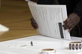 Una persona organiza hojas de votación anticipada en el Centro de votaciones del Centro Comunitario Columbia Heights, en Wahington.