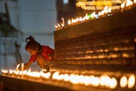 Una niña enciende una vela durante un día de luto por las víctimas de las inundaciones del 26 de agosto en Katmandú, Nepal.