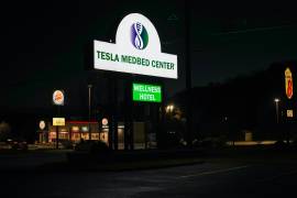Un letrero iluminado frente a un Burger King y un hotel Super 8 muestra la entrada del Tesla Wellness Hotel and MedBed Center, el martes 14 de noviembre de 2023, en Butler, Pensilvania.