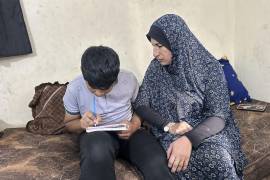 Walá Awad realiza tareas con su hijo en Al Mawasi, Franja de Gaza, donde la terapeuta Nawal Asqul atiende a niños afectados por el trauma de la guerra.