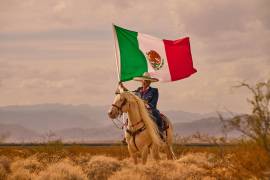Tomás Garcilazo, con la bandera de México en alto, simboliza el orgullo charro y la proyección internacional de la tradición ecuestre mexicana.