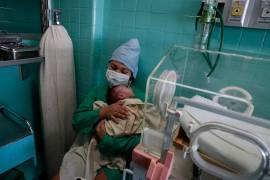 En medio de los cortes de energía que paralizan a Cuba, una enfermera sostiene a un bebé en el Hospital Pediátrico William Soler.