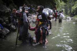 Migrantes haitianos vadean un río mientras cruzan la selva del Darién desde Colombia a Panamá, con la esperanza de llegar a Estados Unidos, el 9 de mayo de 2023.