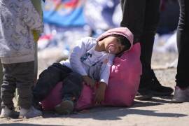 Un niño descansa sobre una bolsa mientras es procesado por la Patrulla Fronteriza de Estados Unidos entre las dos vallas fronterizas en la frontera sur de Estados Unidos con México, en San Diego, California.